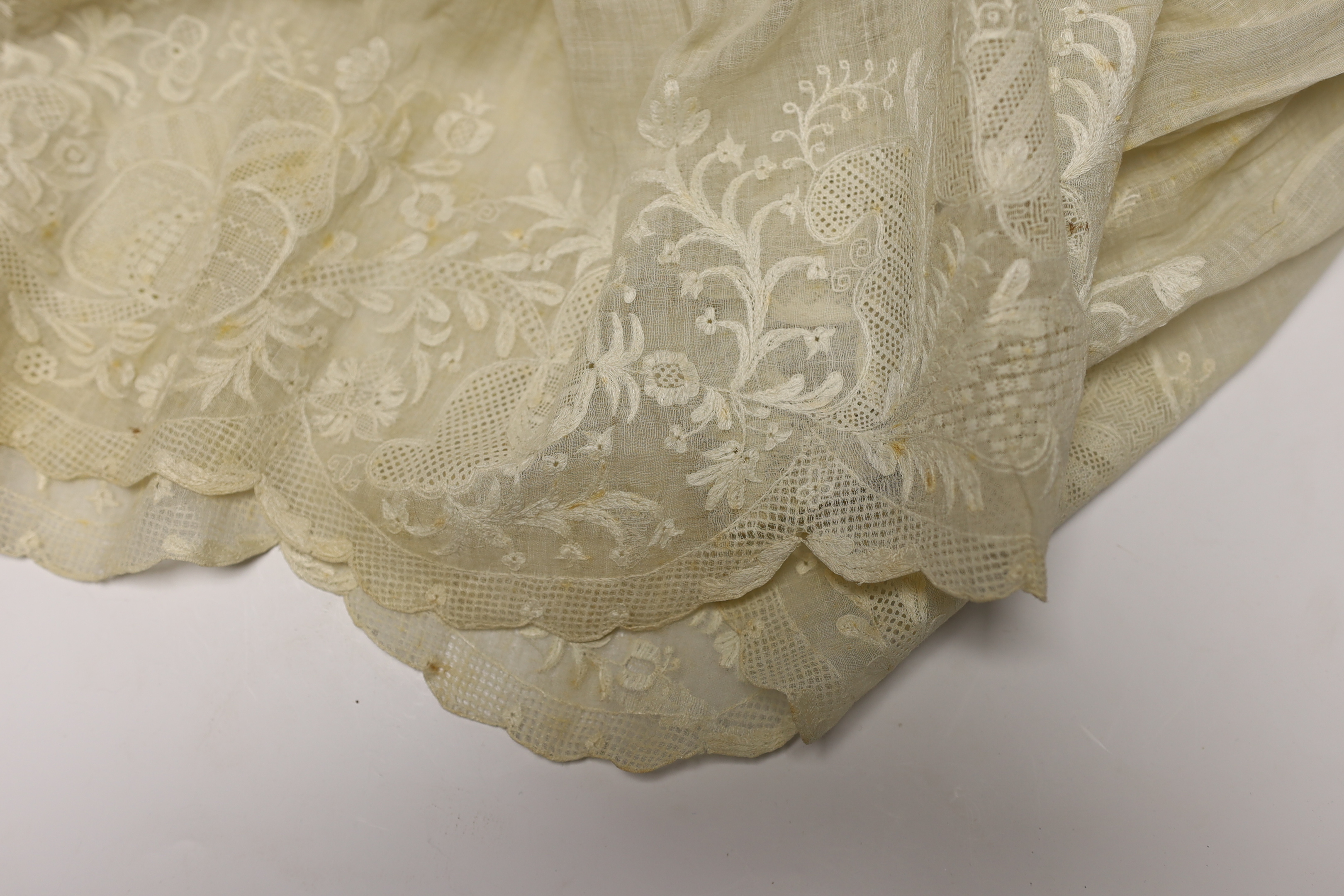 An 18th century Dresden worked apron, a white worked fine lawn stole, two panels of linen ribbon work, a ladies lace bonnet a similar pink satin bonnet a white worked blouse (partially made) and panel to a christening go